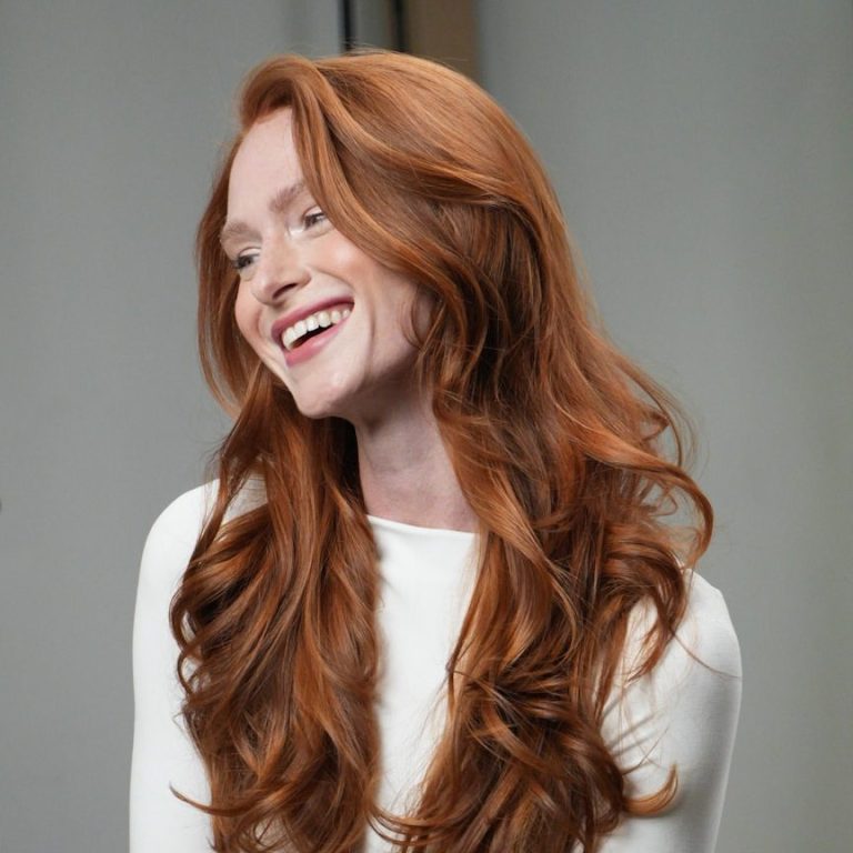 Lockenfrisur Friseur Daniela Blaubeuren Porträt einer Frau mit leuchtend roten, schulterlangen Haaren